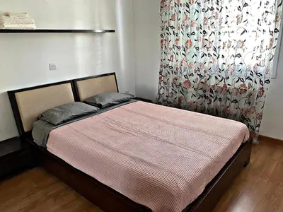 a bed in a room with a curtain and a bed sidx sidx sidx at Charm Flat in the heart of the City Center - Balcony & view in Nicosia