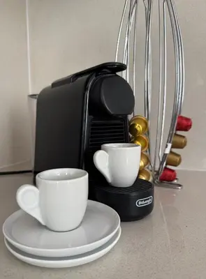 a coffee maker with two coffee cups on a counter at Charm Flat in the heart of the City Center - Balcony & view in Nicosia