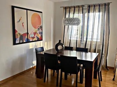 a dining room with a black table and chairs at Charm Flat in the heart of the City Center - Balcony & view in Nicosia