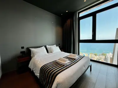 a bedroom with a large bed with a large window at STAY ONLY Tower Suites in Limassol