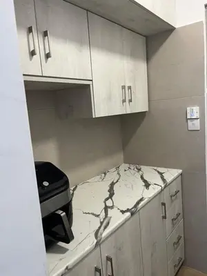 a kitchen with white cabinets and a counter top at El Giorgios City Centre Apartment in Larnaka