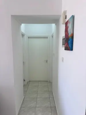 a hallway with a white door and a painting on the wall at Near Makenzie Beach 51 in Larnaka