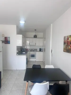 a kitchen with a table and chairs in a room at Near Makenzie Beach 51 in Larnaka
