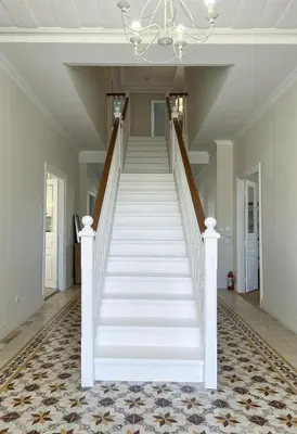 a white staircase in a home with a chandelier at Stou Savvide - Pera Pedi Stone Manor in Perapedhi