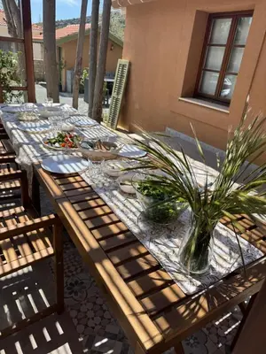a wooden table with plates and plants on a patio at Stou Savvide - Pera Pedi Stone Manor in Perapedhi