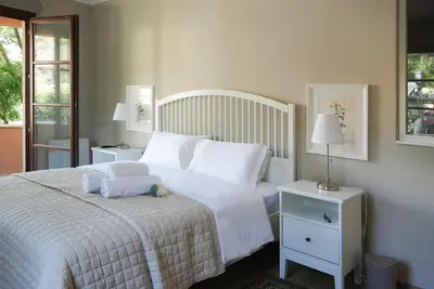 a bedroom with a white bed and two lamps and a window at Stou Savvide - Pera Pedi Stone Manor in Perapedhi