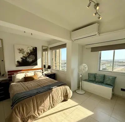 a bedroom with a bed and a fan and windows at Atalanta rooms in Larnaka