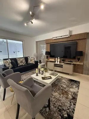 a living room with a couch and a tv at Atalanta rooms in Larnaka