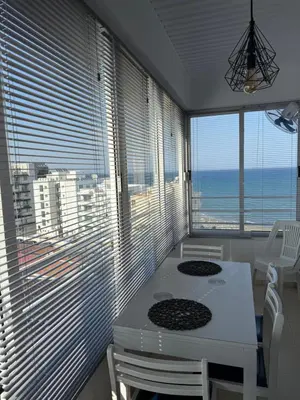 a dining room with a table and a view of the ocean at Atalanta rooms in Larnaka