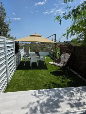 a patio with a table and a large umbrella at Protaras Ayios Elias Maisonette in Protaras