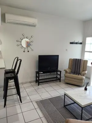 a living room with a tv and a chair at White House with Garden and BBQ in Strovolos in Nicosia