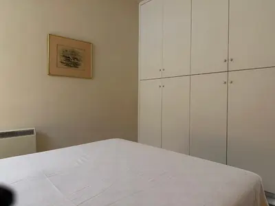a white bedroom with white cabinets and a bed at White House with Garden and BBQ in Strovolos in Nicosia