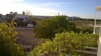 a view of a field with trees and a building at Quiet Top Floor One Bedroom Apartment in Pyla Near Beach in Voroklini