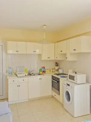 a kitchen with white cabinets and a washing machine at Quiet Top Floor One Bedroom Apartment in Pyla Near Beach in Voroklini