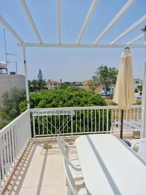 a patio with a table and an umbrella at Quiet Top Floor One Bedroom Apartment in Pyla Near Beach in Voroklini