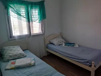 a small bedroom with two beds and a window at Однокомнатная квартира на берегу моря in Zygi