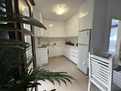 a kitchen with white cabinets and a white refrigerator at Modern 2BR Apartment 70m from Finikoudes beach in Larnaka