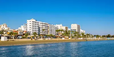 a view of a beach with buildings in the background at Modern 2BR Apartment 70m from Finikoudes beach in Larnaka