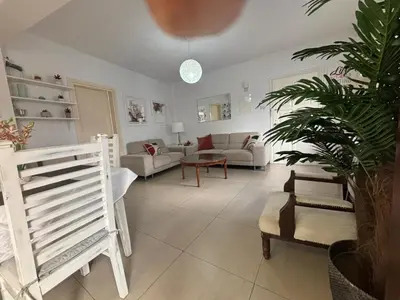 a living room with a couch and a table at Modern 2BR Apartment 70m from Finikoudes beach in Larnaka