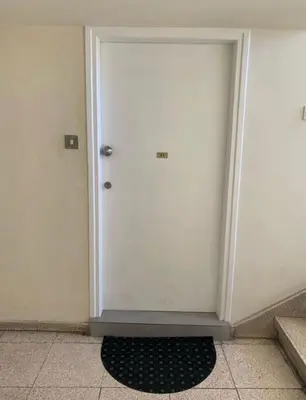 a white door in a room with a black rug at Millenia Apartment in Nicosia