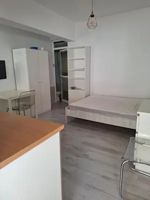 a white room with a bed and a table at Comfortable Ground Floor Studio in Limassol in Limassol