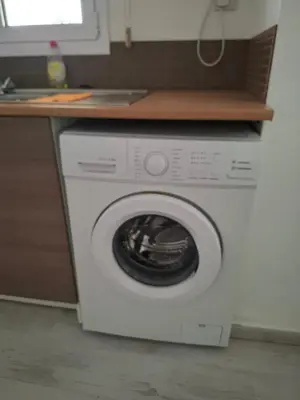 a washing machine under a counter in a kitchen at Comfortable Ground Floor Studio in Limassol in Limassol