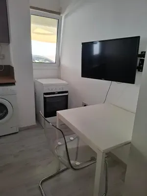 a small kitchen with a table and a tv on the wall at Comfortable Ground Floor Studio in Limassol in Limassol