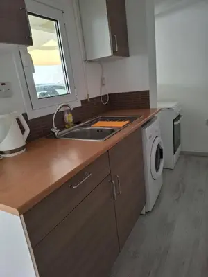 a kitchen with a sink and a washing machine at Comfortable Ground Floor Studio in Limassol in Limassol