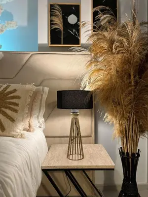 a table with a lamp on it next to a bed at Boho Studio mit Meerblick in Boğaz