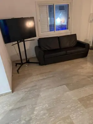 a living room with a black couch and a flat screen tv at Protaras entire house in Protaras
