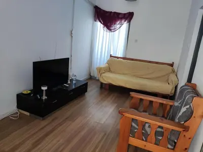 a living room with a couch and a flat screen tv at A separate room with a shared bathroom and 50 meters from the sea in Zygi