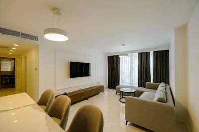a living room with a couch and a tv at 2Bedroom Apartment in Grand Sapphire Complex Featuring a Pool and Casino in Lemithou