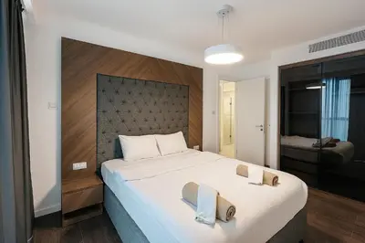 a bedroom with a large bed with two towels on it at 2Bedroom Apartment in Grand Sapphire Complex Featuring a Pool and Casino in Lemithou