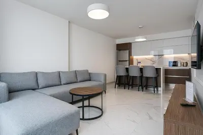 a living room with a couch and a table and a kitchen at 2Bedroom Apartment in Grand Sapphire Complex Featuring a Pool and Casino in Lemithou