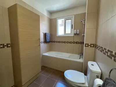 a bathroom with a toilet and a bath tub at Majestic Gardens 10 minutes from Larnaka Airport in Tersephanou