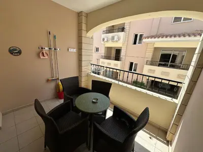 a room with a table and chairs and a balcony at Majestic Gardens 10 minutes from Larnaka Airport in Tersephanou