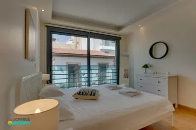 a bedroom with a bed and a large window at Dios Ponte 102 Beachfront in Larnaka