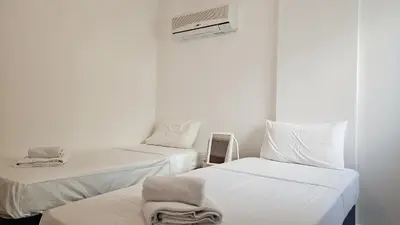 two beds in a white room with a air conditioner at STAY Miracle Apartment in Larnaka