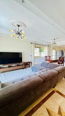 a large couch in a living room with a flat screen tv at Alkeou Holiday Home in Limassol