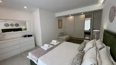 a white room with a bed and a mirror at Kantara Garden Apt by TrulyCyprus in Limassol
