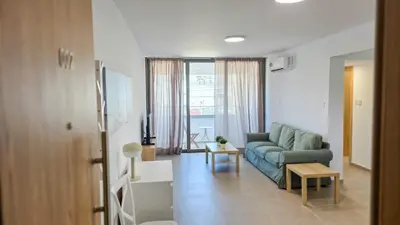 a living room with a couch and a table at Olive Dunes Stay in Larnaka