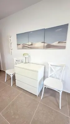 a white dresser and two chairs in a room at Olive Dunes Stay in Larnaka