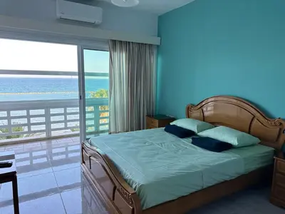 a bedroom with a bed with a view of the ocean at GARNET Beach Apartment in Voroklini