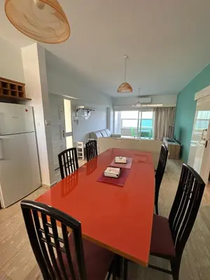 a kitchen and dining room with a red table and chairs at GARNET Beach Apartment in Voroklini