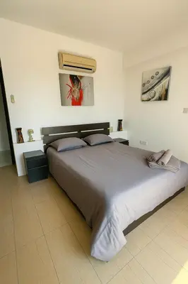 a bedroom with a large bed with two pillows at Sunflight Apt 01B One Bedroom Apt in Larnaka