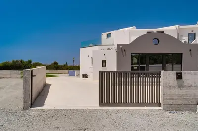 a white building with a gate in front of it at Exclusive 7-Bdr Villa with Panoramic Views & Saltwater swimming pool! in Ayia Napa