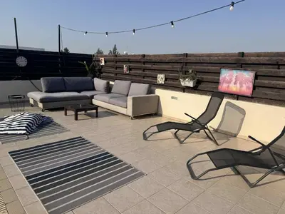a patio with a couch and chairs and a tv at Dali Villa in Dhali