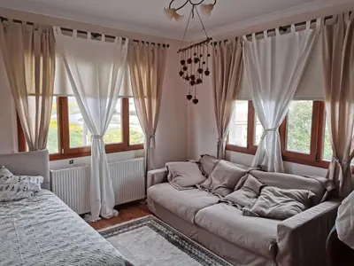 a living room with a couch in front of windows at Live in landlord guest house panthea in Limassol
