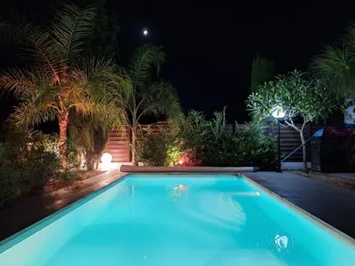 a swimming pool in a yard at night at Live in landlord guest house panthea in Limassol