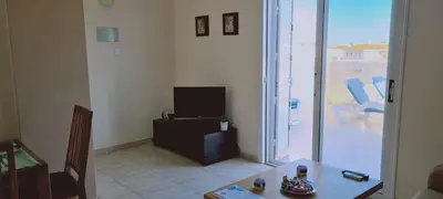 a living room with a table and a television and a balcony at STAY Sunshine Apartment in Protaras